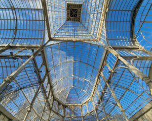An interesting combination of glass and metal in Palacio de Cristal located in the de El Retiro park in Madrid on a sunny day, Madrid, Spain.
