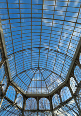 An interesting combination of glass and metal in Palacio de Cristal located in the de El Retiro park in Madrid on a sunny day, Madrid, Spain.