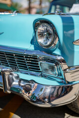 Closeup of a headlight of a blue classic vintage antique car