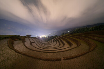 Fototapeta na wymiar Fresh paddy rice, green agricultural fields in countryside or rural area of Mu Cang Chai at night, mountain hills valley in Asia, Vietnam. Nature landscape background.