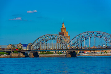 view of the zeppelin hangars and the academy of sciences building next to a steel railway bridge in the Latvian capital Riga. © dudlajzov