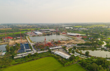 Aerial view of busy industrial under construction site workers working with cranes and excavators. Top view of precast concrete slap floor full of steel. Development high rise architecture building.