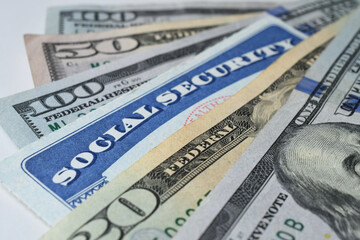 Social Security Card with cash money dollar bills - living on a fixed income, benefits SSN
