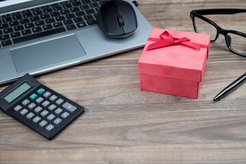 A red gift box on the office table. Employee appreciation concept