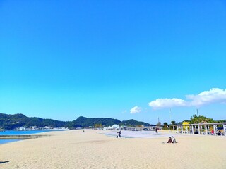 日本の和歌山県の観光地、快水浴百選海の部特選にも選ばれた片男波海水浴場の海と砂浜と晴れた青空が美しい夏の風景（コピースペースあり）