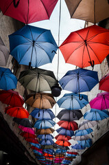 Bright and colorful hanging umbrellas over the street against the sky. multicolor street decoration