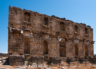 View of partially reconstructed facade of Nymphaeum building at archaeological site of ancient city of Aspendos on sunny day, Turkey..