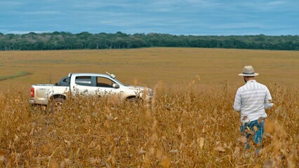 Farmer driving pickup truck in soy farm © Marcelo