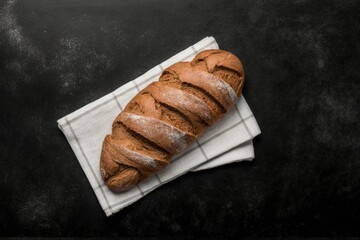 freshly baked bread on top of a tea towel on the black stone table