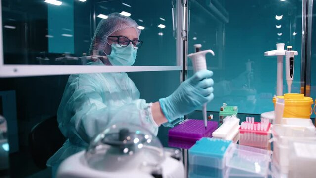 Doctor taking samples from blue tray and putting them in PCR test tubes while discarding used ones. This work requires precision and careful and stady hands. High quality 4k footage 