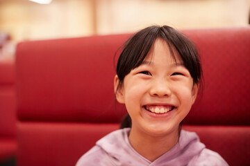 外食の店で笑顔している小学生の女の子の姿