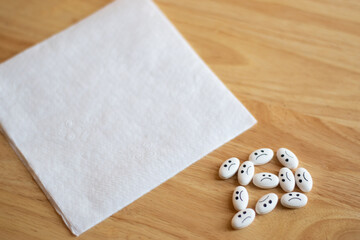 Medicine pills with sad face with depression concept and an empty letter in a wood table with focus in the pills