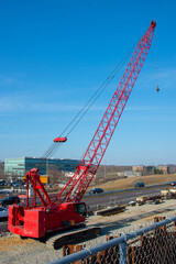 Fototapeta na wymiar red truck crane boom with hooks and scale weight above blue sky