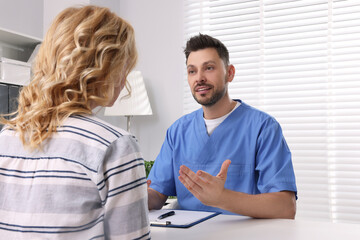 Obraz premium Doctor with clipboard consulting patient in clinic