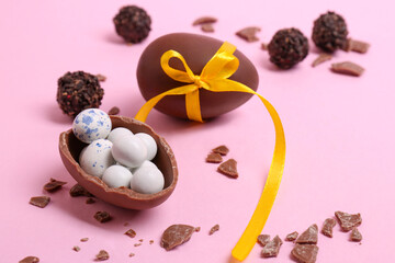 Obraz na płótnie Canvas Tasty chocolate eggs and candies on pink background