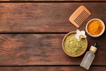 Flat lay composition with henna and turmeric powder on wooden table, space for text
