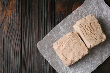 Fresh compressed yeast on wooden table, top view. Space for text