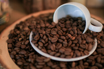 Roasted coffee beans in white cup. retro style toned, copy space. Background and texture of roasted coffee beans