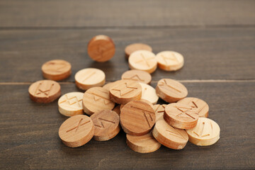 Pile of runes with different symbols on wooden table