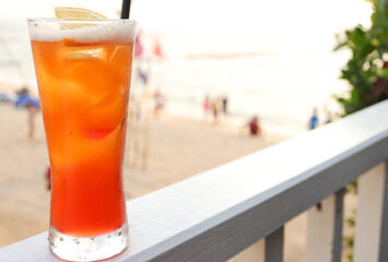 Glass of cocktails with straws. Delicious beverages. Blur sea beach in background. Travel and vacation concept