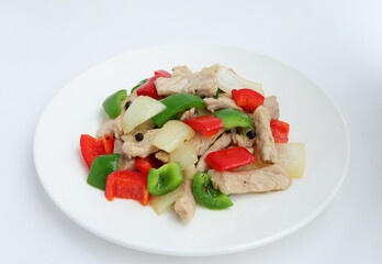 Top view. Delicious homemade Stir fried pork with sweet peppers, onion and black pepper on white plate. 