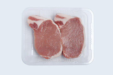 Sliced raw pork meat in plastic tray on white background. Top view with clipping path.