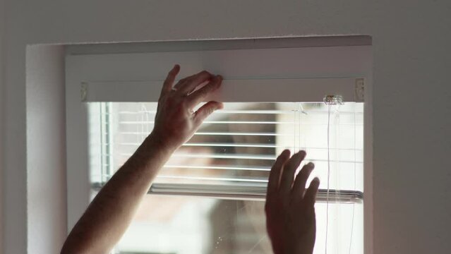 Close-up, man's hand with a screwdriver tightens the fixing screw of the window blinds