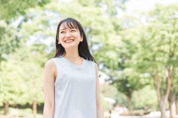 新緑の中にいる笑顔の日本人女性
