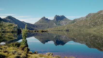 wide angle shot of a mirror calm dove lake with cradle mountain in the distance