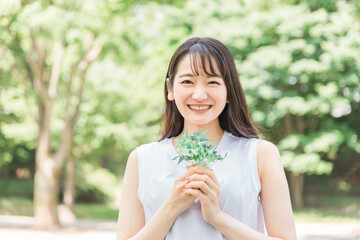 植物を持つ笑顔の日本人女性
