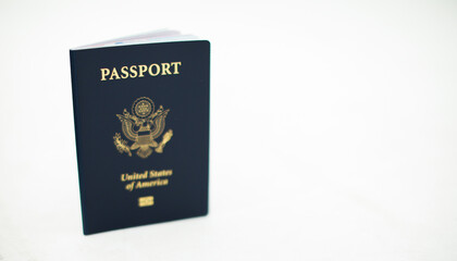 Close-up of a US passport with immigration, visa, citizenship, and travel paperwork on a wooden...