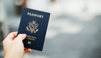 Close-up of a US passport with immigration, visa, citizenship, and travel paperwork on a wooden...