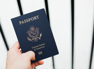 Close-up of a US passport with immigration, visa, citizenship, and travel paperwork on a wooden...