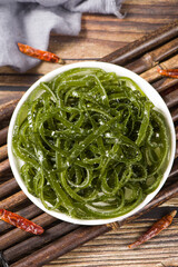 Fresh shredded kelp in plate on table.