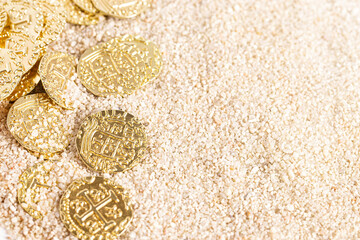 Buried Pirate Treasure Gold Coins in the Sand on a Sandy Beach