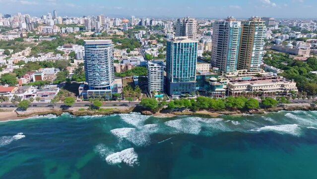 Aerial trucking shot showing skyline of Santo Domingo with luxury towers in summer