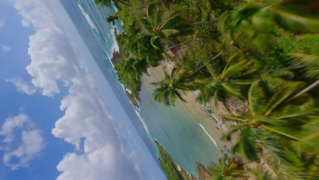 Dynamic drone flight over PLAYA LOS COQUITOS with blue colored Caribbean Sea with cloudy sky in Dominican Republic