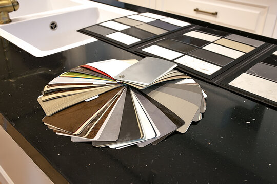 samples of marble tiles with sampler of wooden baseboards and colors swatches, on blueprint drawing with model of houses, interior design, finishing design shop, house materials planning and sale