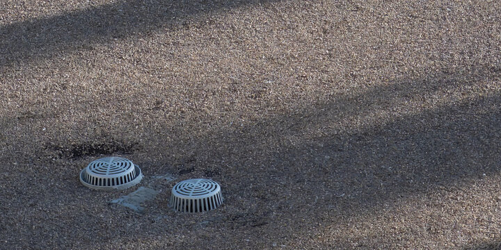 Flat building roof top with ventilation and covered stormwater intake visible. 
