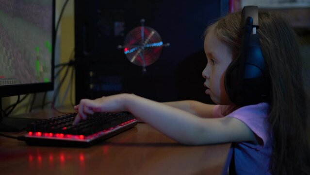 A child with headphones plays an online video game on the computer. The problem of Computer Game Addiction in Children. Entertainment during the lockdown