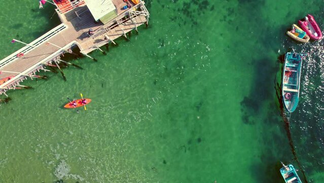 Top-down shot of kayakers and a tourist boat ready for departure at Pejerrey dock