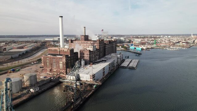 Industrial factory with American flag, shipping cranes. East coast, USA