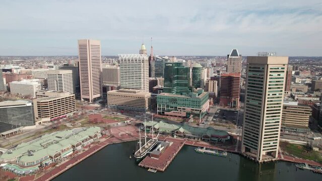 Close-up drone shot of downtown Baltimore with historic ships waterfront area in the foreground.