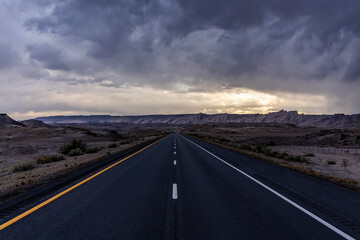 Road to the horizon between mountains and deserts. Beautiful view of way to infinity. Us road and highway extends the west