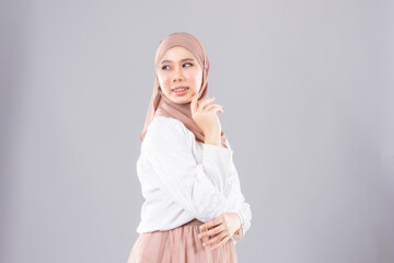 Young smiling confident asian muslim woman in hijab over isolated over background studio. Casual hijab fashion.