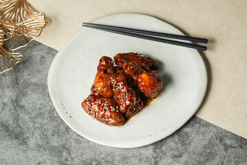 Deep-fried chicken with korean style sauce on white plate.