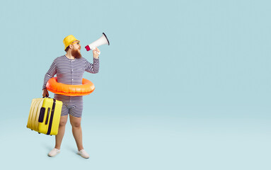 Funny traveler in swimsuit and inflatable ring standing on blank text copyspace studio background, holding suitcase and megaphone, offering cheap airplane tickets sale and fun summer holiday overseas