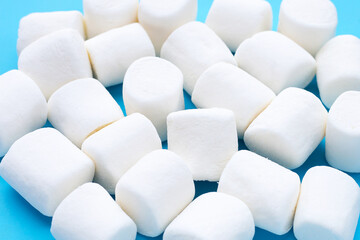 Obraz premium Delicious white marshmallows on blue background.