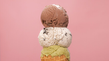 Close-up of three ice cream flavors stacked on top of an ice cream cone.