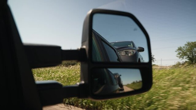 interesting view of a car hauled by a wedge car trailers-carhauling. With small reflection in the window. Trailer is pulled by a pickup truck. Similar view as tow truck